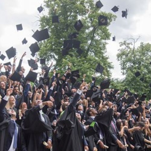 Graduates throwing hats into the air
